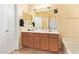 This bathroom has dual sinks, a bathtub, wood cabinets and tiled flooring at 1619 E Aspen Ave, Buckeye, AZ 85326