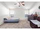 This bedroom has a ceiling fan, 2 windows, carpet flooring, and a seating area at 1619 E Aspen Ave, Buckeye, AZ 85326