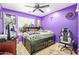 The purple room has a bed, an office chair, carpet, and a ceiling fan at 1619 E Aspen Ave, Buckeye, AZ 85326