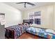 This bedroom features two beds, wood laminate floors, a window, and overhead lighting at 1619 E Aspen Ave, Buckeye, AZ 85326