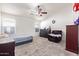 Spacious bedroom with a ceiling fan, dresser, carpet, and seating area at 1619 E Aspen Ave, Buckeye, AZ 85326