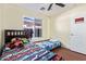 This bedroom has two beds, wood laminate floors, overhead lighting, and a window at 1619 E Aspen Ave, Buckeye, AZ 85326