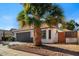 Landscaped front yard featuring a mature palm tree, and an attached two-car garage at 1736 E Bluefield Ave, Phoenix, AZ 85022