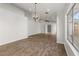 Large living room with wood-look tile floors, modern light fixture, and vaulted ceiling at 1736 E Bluefield Ave, Phoenix, AZ 85022