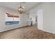 Bright living room featuring wood-look tile floors, modern light fixture, and view into the kitchen at 1736 E Bluefield Ave, Phoenix, AZ 85022