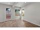 Sunlit room with wood flooring and a window and glass paneled door to the backyard at 1736 E Bluefield Ave, Phoenix, AZ 85022