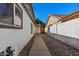 A narrow side yard featuring a concrete pathway and rock landscaping, perfect for low-maintenance living at 1736 E Bluefield Ave, Phoenix, AZ 85022