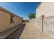 Side yard of home showcasing gravel landscaping and block wall fencing for optimal privacy and space at 17611 W Watson Ln, Surprise, AZ 85388