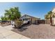 View of the driveway of this home with desert landscaping, tall trees, and a white truck at 17611 W Watson Ln, Surprise, AZ 85388