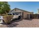 Home's garage featuring gravel landscaping, and the side gate entrance to the backyard at 17611 W Watson Ln, Surprise, AZ 85388