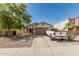 Charming home featuring desert landscaping, an American flag, and an attached two-car garage at 17611 W Watson Ln, Surprise, AZ 85388