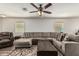 Bright living room featuring a large sectional sofa, ceiling fan, and stylish decor at 17611 W Watson Ln, Surprise, AZ 85388
