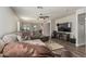 Inviting living room with comfortable seating, wood floors, and a view to the dining area at 17611 W Watson Ln, Surprise, AZ 85388