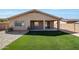 Clean backyard features covered patio, artificial turf, and rock landscaping at 18371 W Capistrano Ave, Goodyear, AZ 85338