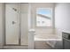 Bright bathroom featuring a walk-in shower and a soaking tub with modern fixtures and bright lighting at 18371 W Capistrano Ave, Goodyear, AZ 85338