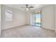 Spacious bedroom featuring a ceiling fan, bright windows, and sliding glass door to the backyard at 18371 W Capistrano Ave, Goodyear, AZ 85338