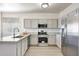 Well-lit kitchen with stainless steel appliances, granite countertops, and light gray cabinets at 18371 W Capistrano Ave, Goodyear, AZ 85338