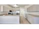 Kitchen boasts stainless appliances, granite countertops, light gray cabinets, and wood look floors at 18371 W Capistrano Ave, Goodyear, AZ 85338