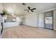 Open-concept living area with a kitchen island, a fireplace, modern lighting and wood-style flooring at 18371 W Capistrano Ave, Goodyear, AZ 85338