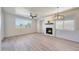 Bright living room with a modern fireplace, ceiling fan and natural light from the window at 18371 W Capistrano Ave, Goodyear, AZ 85338