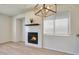 Bright living room featuring a tile fireplace, modern light fixture, and window with horizontal blinds at 18371 W Capistrano Ave, Goodyear, AZ 85338