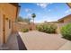 Private backyard offers a brick patio, mature shrubbery, and palm tree views at 18416 N Spanish Garden Dr, Sun City West, AZ 85375
