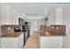 Galley kitchen features stainless steel appliances and granite countertops at 18416 N Spanish Garden Dr, Sun City West, AZ 85375