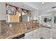 Kitchen features white cabinets, stainless steel sink and granite countertops at 18416 N Spanish Garden Dr, Sun City West, AZ 85375