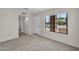 Open living area with a window and door to a hallway at 18416 N Spanish Garden Dr, Sun City West, AZ 85375