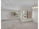 Bright living room featuring large windows and neutral carpeting at 18416 N Spanish Garden Dr, Sun City West, AZ 85375