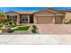 Charming single-story home with a well-manicured front yard and brick-paved driveway leading to a two-car garage at 18908 W Montebello Ave, Litchfield Park, AZ 85340