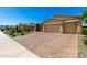 Inviting front exterior showcasing lush landscaping and a brick-paved driveway leading to a two-car garage at 18908 W Montebello Ave, Litchfield Park, AZ 85340