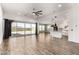 Open floor plan combining living, dining, and kitchen spaces, featuring wood-look tile and a large sliding glass door at 18908 W Montebello Ave, Litchfield Park, AZ 85340