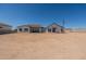 Back exterior showcasing large windows, a covered patio, and the expansive backyard at 2095 N 77Th Pl, Mesa, AZ 85207