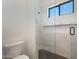 A bathroom showcases a modern glass-door shower with white tiled walls and neutral-colored flooring at 2095 N 77Th Pl, Mesa, AZ 85207