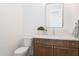A cozy half-bathroom showcases stone countertops and wooden cabinets with modern fixtures and decor at 2095 N 77Th Pl, Mesa, AZ 85207