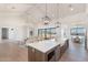 Open-concept kitchen with stainless steel appliances, large island with seating, and seamless flow to living and dining areas at 2095 N 77Th Pl, Mesa, AZ 85207
