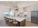 Elegant kitchen with a large island, stainless steel appliances, pendant lighting, and bar stool seating at 2095 N 77Th Pl, Mesa, AZ 85207