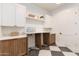 This laundry room shows custom cabinets, shelving, stone countertops and a trendy checkerboard floor at 2095 N 77Th Pl, Mesa, AZ 85207