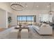 Sunlit living room features neutral sofas, a wood coffee table, and large sliding doors leading to an outdoor area at 2095 N 77Th Pl, Mesa, AZ 85207