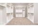 A stunning walk-in closet featuring custom shelving, rod space, and neutral carpeting for optimal organization at 2095 N 77Th Pl, Mesa, AZ 85207