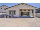 The backyard of a tan house featuring a covered patio and desert landscaping with mountain views at 21276 W Mariposa St, Buckeye, AZ 85396