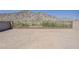Backyard with a low brick retaining wall and a wrought iron fence showing desert vegetation on a hill at 21276 W Mariposa St, Buckeye, AZ 85396