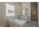 Modern bathroom featuring a sleek bathtub, walk-in shower, and natural light at 21276 W Mariposa St, Buckeye, AZ 85396