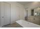 Modern bathroom featuring a sleek freestanding tub, vanity, and neutral color palette at 21276 W Mariposa St, Buckeye, AZ 85396