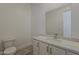 Powder room featuring a modern vanity with a white countertop and stylish mirror at 21276 W Mariposa St, Buckeye, AZ 85396