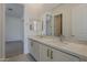Bright bathroom featuring double sinks with modern fixtures, white cabinetry, and a large mirror at 21276 W Mariposa St, Buckeye, AZ 85396