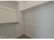 Empty closet with built-in shelving and rods for ample storage space, and carpet at 21276 W Mariposa St, Buckeye, AZ 85396