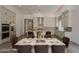 Open dining area with modern chandelier, dining table, and chairs, flowing into a bright kitchen at 21276 W Mariposa St, Buckeye, AZ 85396
