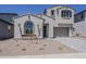 Two-story home features neutral stucco, tiled roof, arched window, and two-car garage with a paved driveway at 21276 W Mariposa St, Buckeye, AZ 85396